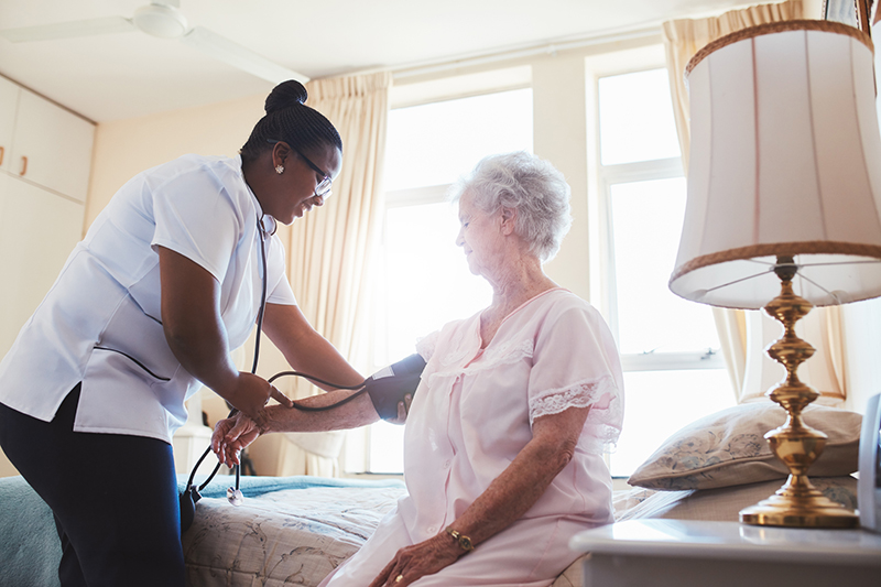 A nurse is checking the health of an elderly woman in Denison, Texas.